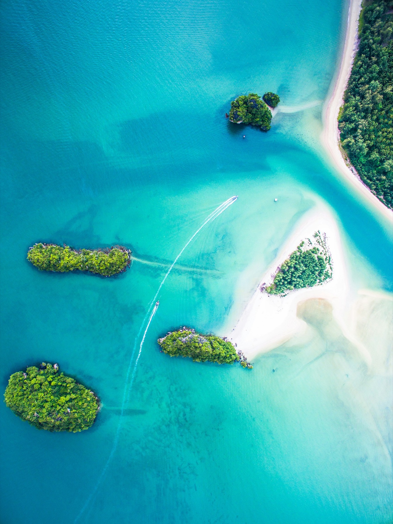 Aerial view of jungle islets and sandbars in turquoise water — the Riau archipelago off Batam.