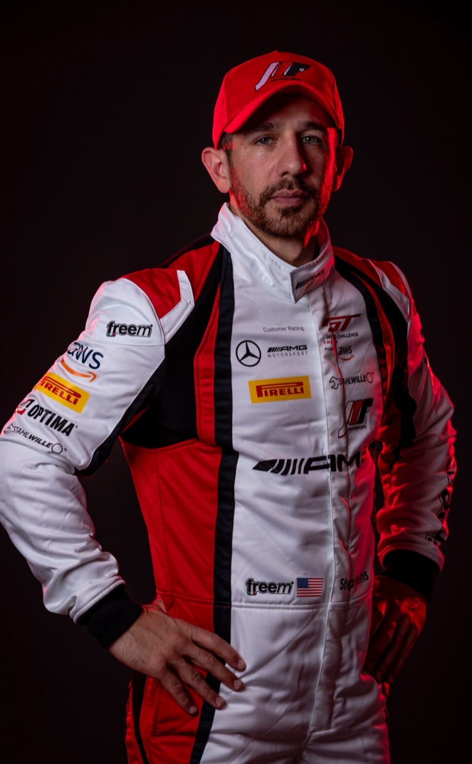 Michai Stephens in a white and red Mercedes-AMG GT racing suit and cap.